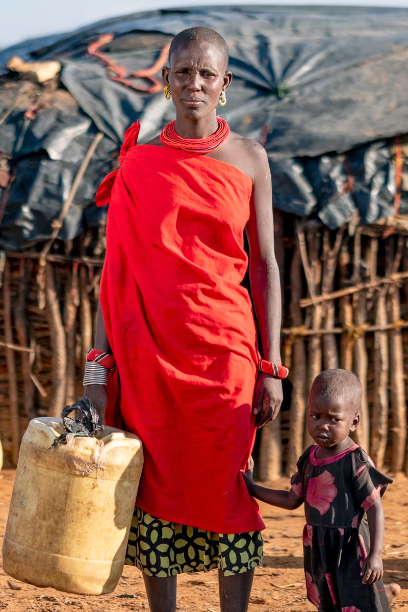 A mom and her child hold a jerry can in need of clean water.